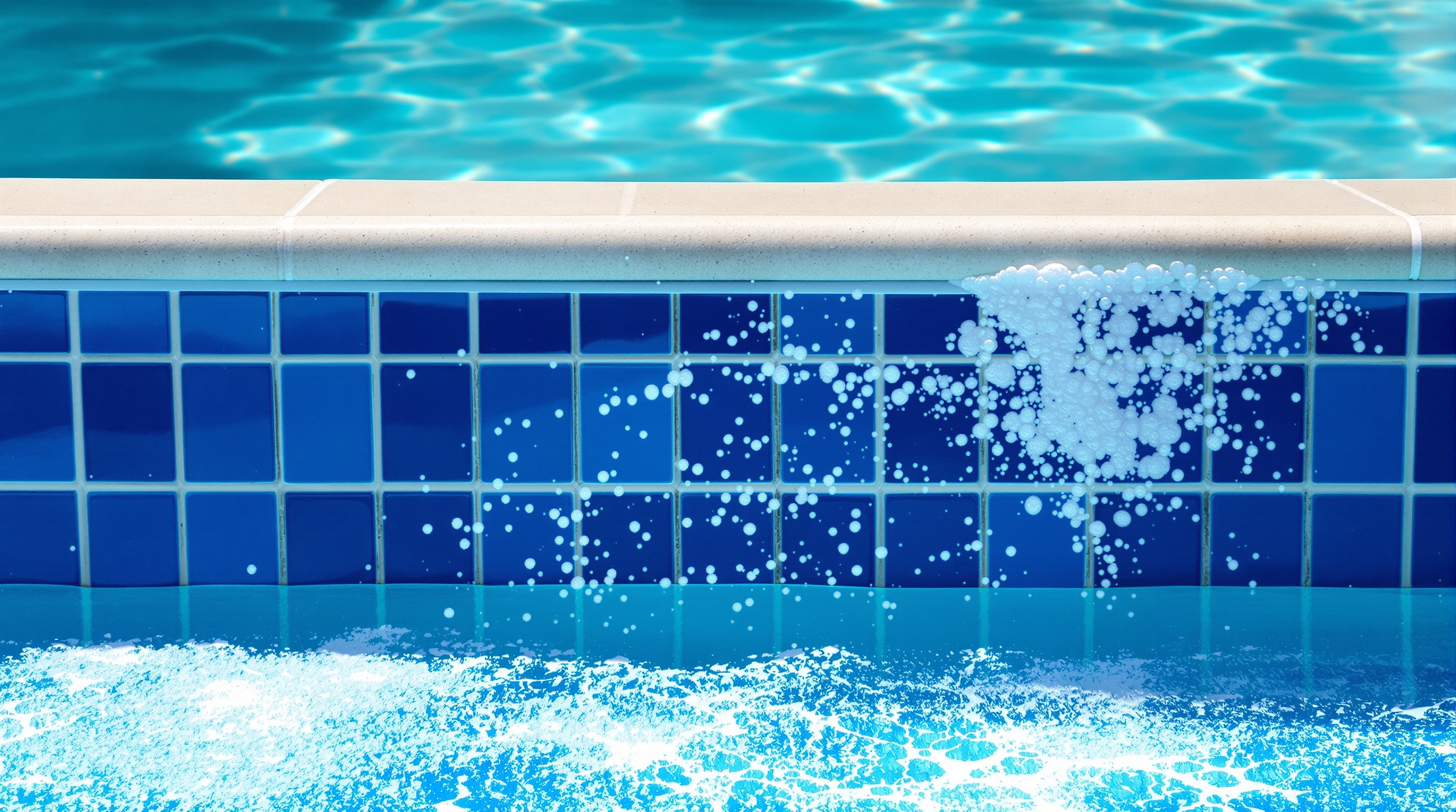 Cobalt blue pool waterline tile being cleaned, showing the contrast between scaled and clean tile